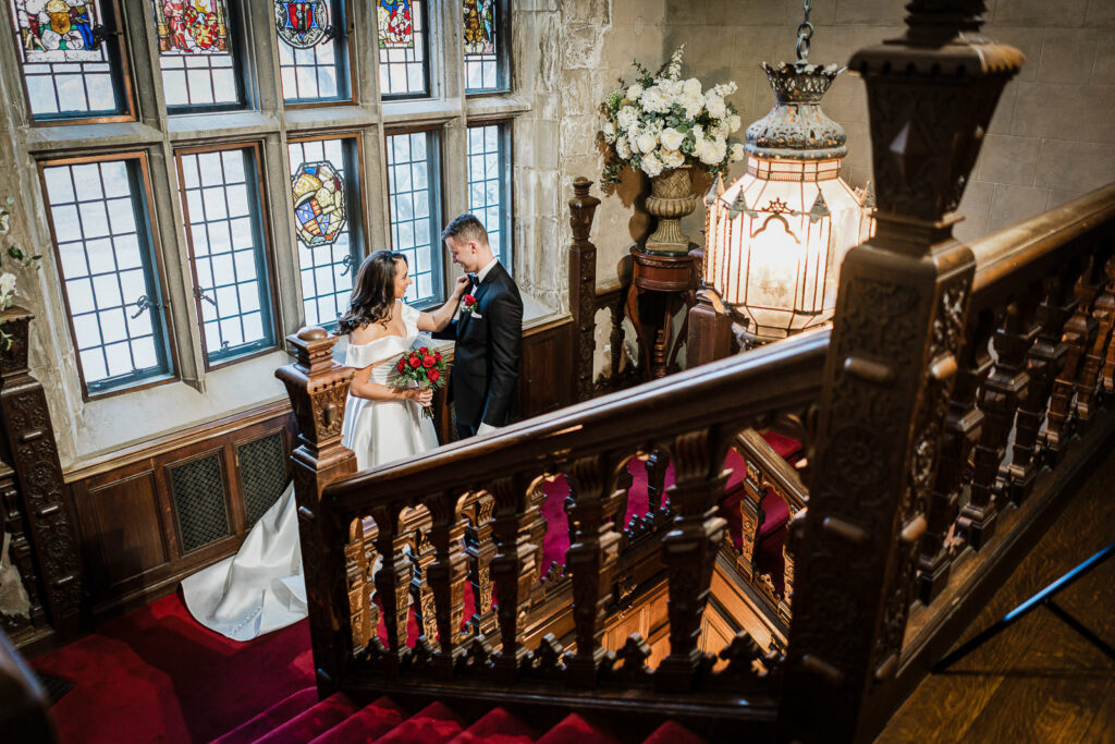 Newlyweds on ornate spiral staircase at Skylands Manor