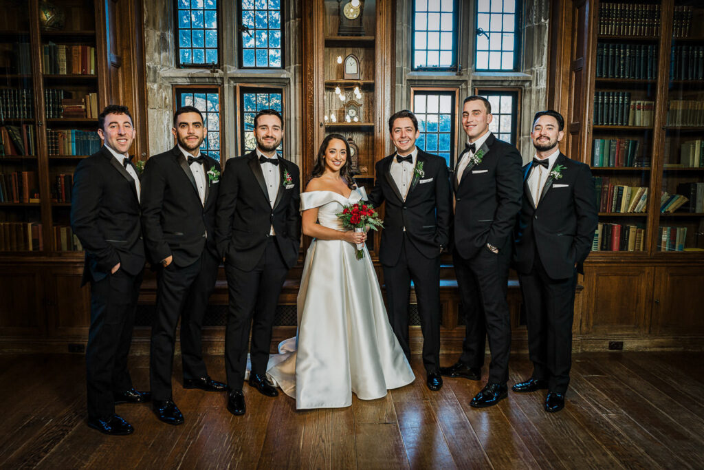 Bride with groomsmen in black tuxedos at Skylands Manor