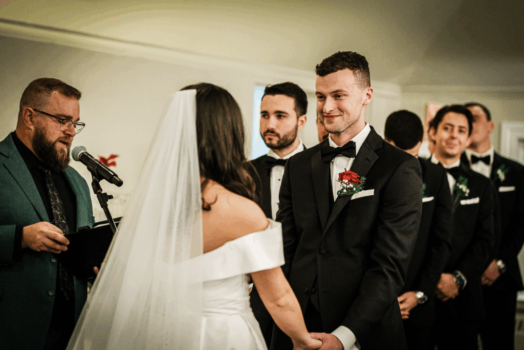 Groom watching bride during wedding ceremony at Skylands Manor