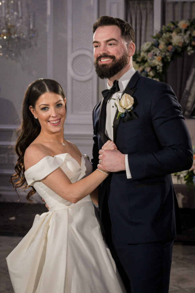 Couple smiling during dance at ballroom wedding reception