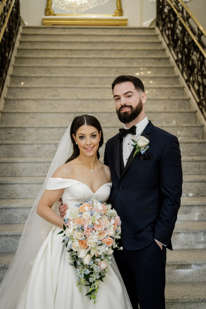 Bride and groom formal portrait on elegant staircase at winter wedding