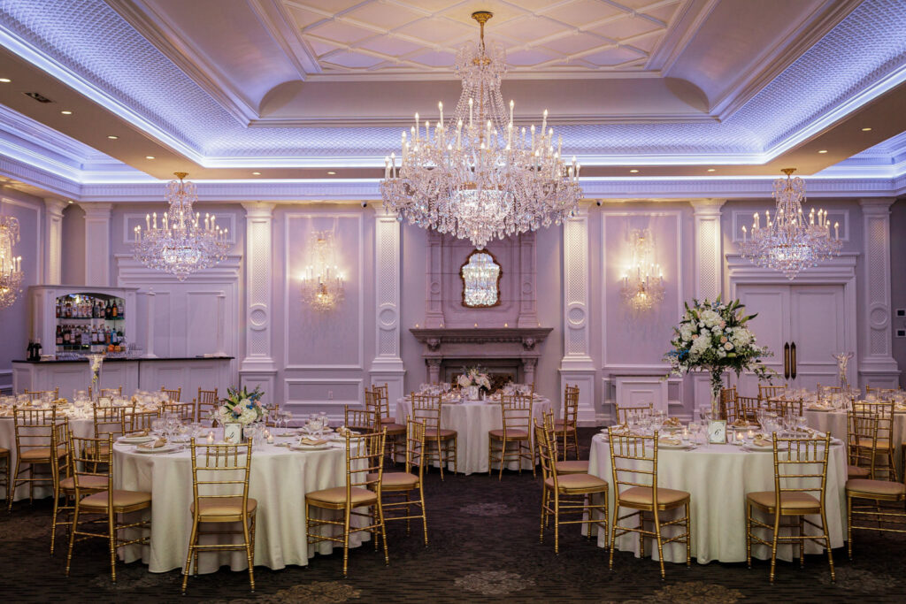 Grand ballroom reception setup with crystal chandeliers at winter wedding
