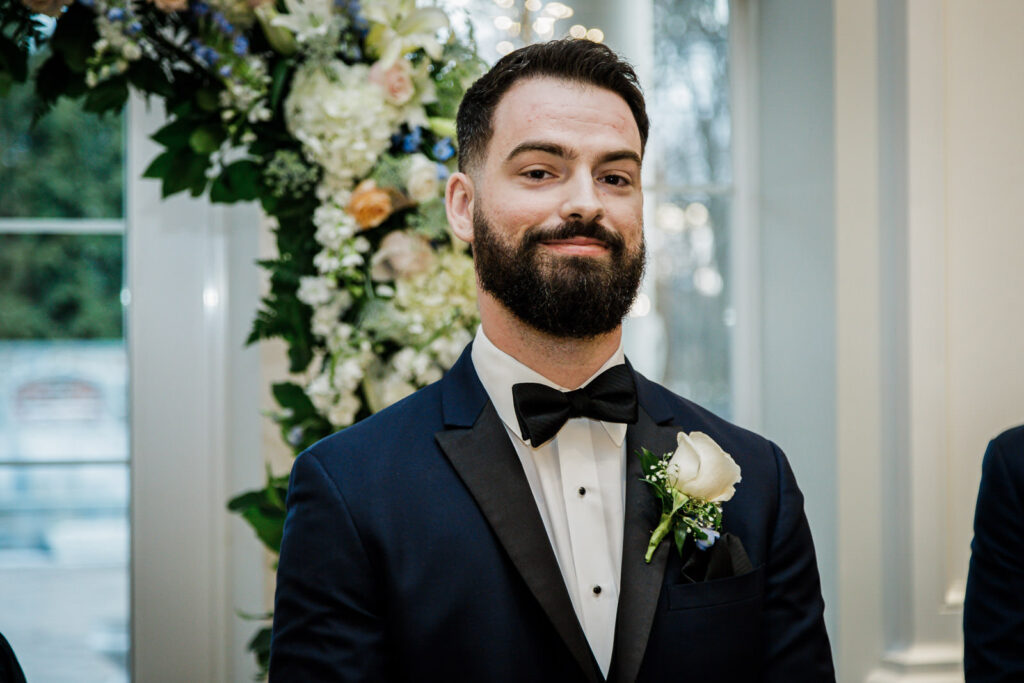 Groom in navy tuxedo with white rose boutonniere at New Jersey winter wedding