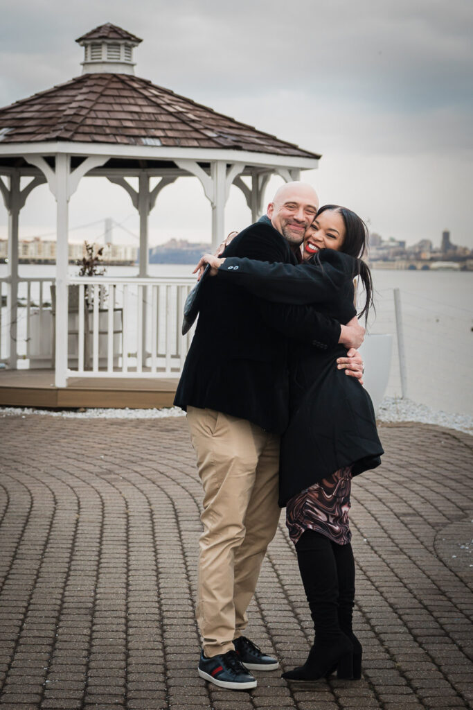 Couple embracing at Waterside Restaurant Hudson River gazebo with New York City skyline, North Bergen