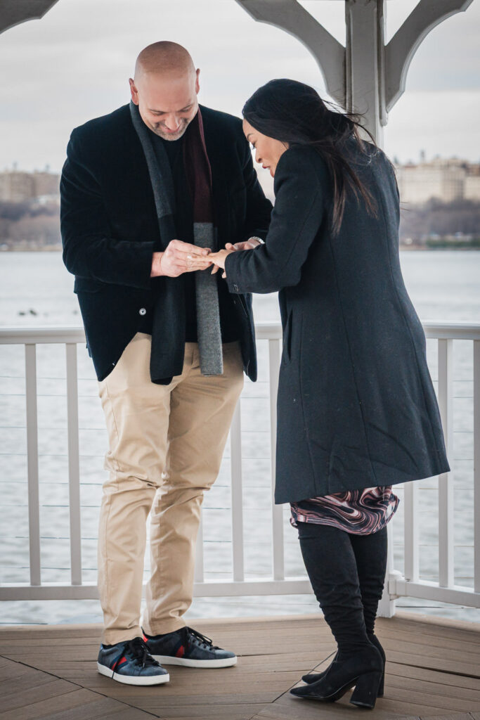 Newly engaged couple examining diamond ring after Hudson River proposal at Waterside Restaurant North Bergen