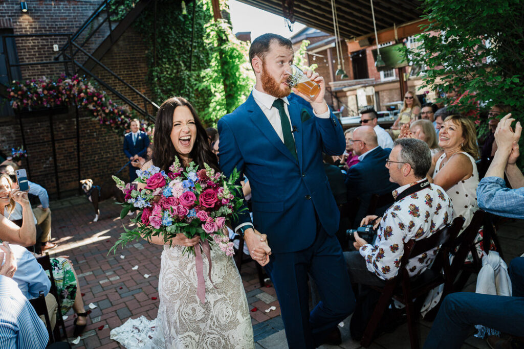 Bride and groom celebrating their recessional with big smiles and a vibrant bouquet at a North Jersey wedding