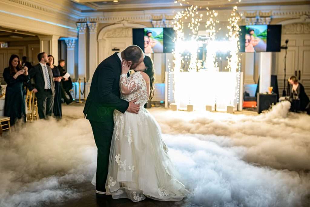 Bride and groom share their first dance surrounded by golden fireworks and low fog at The Park Savoy Estate wedding reception in New Jersey