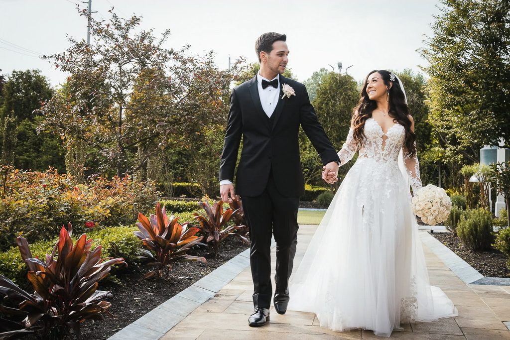 Bride and groom walking through a garden during Bergen County wedding portraits