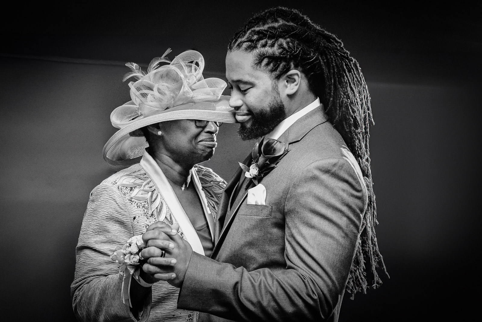 Alt Text: Mother and groom share an emotional mother-son dance at a New Jersey wedding reception, photographed in black and white.
