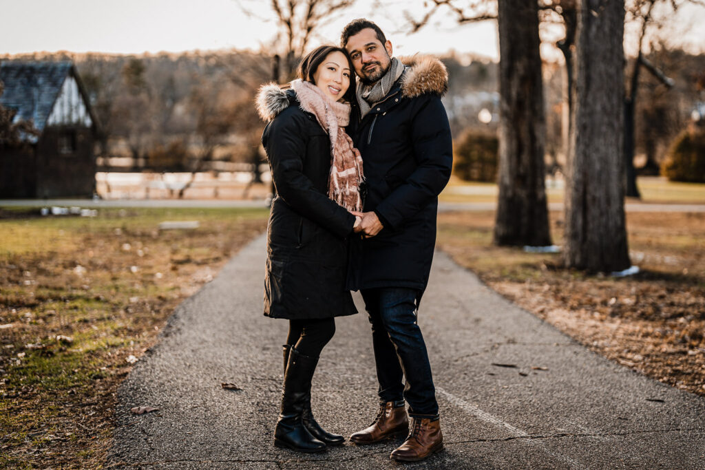 Engaged couple smiling naturally together during outdoor park engagement session in New Jersey