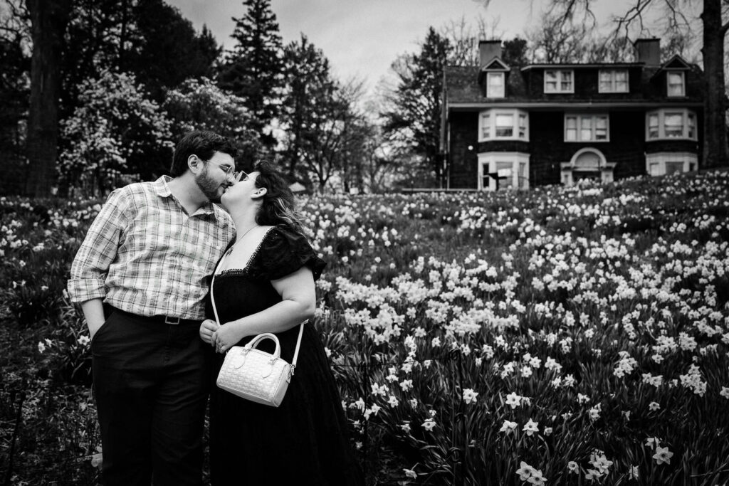 Black and white photo of couple kissing in daffodil field at Reeves-Reed Arboretum New Jersey