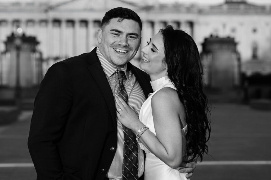 Black and white close portrait of couple laughing together in front of the US Capitol Washington DC