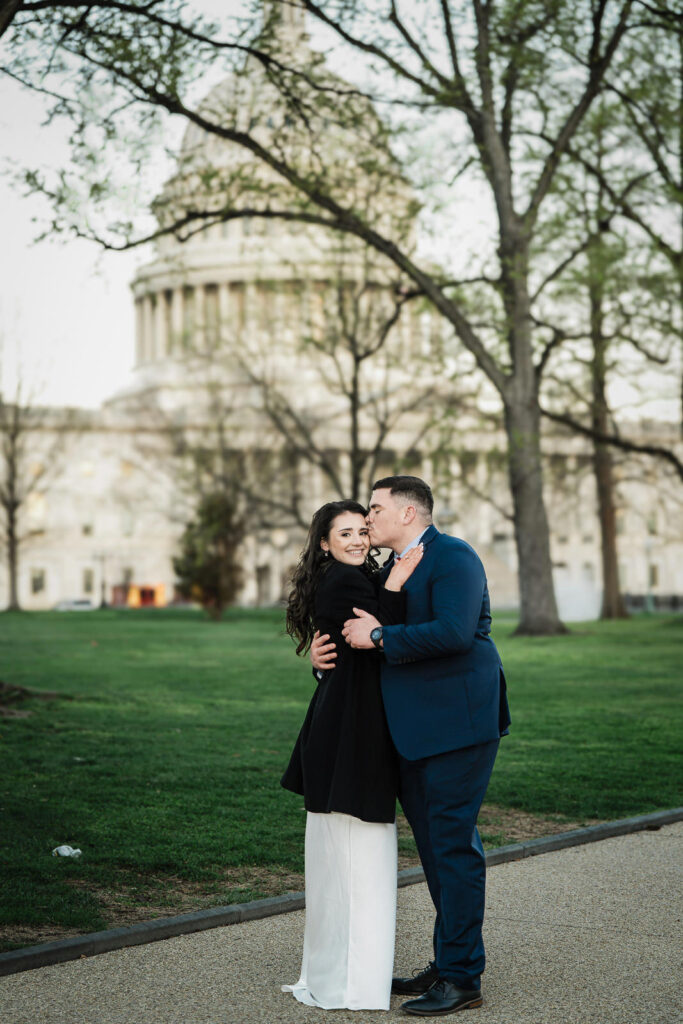 Man kissing his partner on the cheek from behind on the US Capitol grounds Washington DC