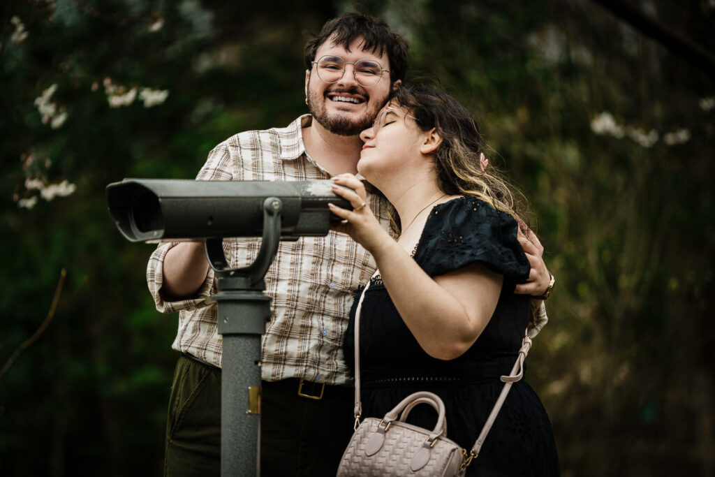 Couple laughing together at coin-operated binoculars at Reeves-Reed Arboretum in Summit New Jersey