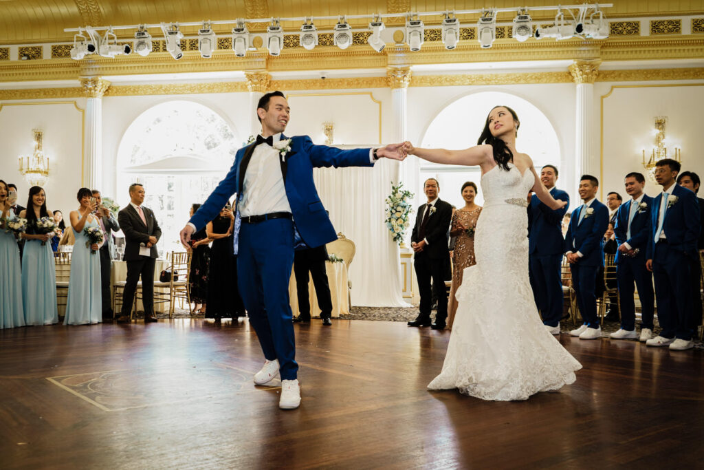 Wide photo of bride and groom dancing in the Crystal Plaza ballroom during their first dance in Livingston NJ