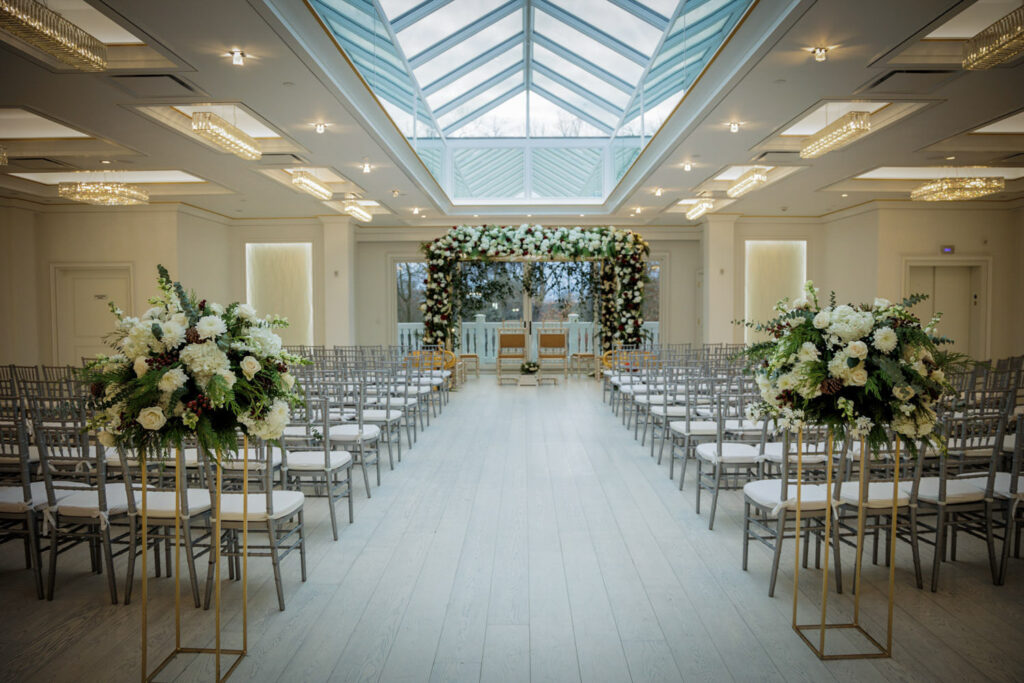 Crystal Plaza wedding ceremony room with glass skylight mandap arch and white floral arrangements