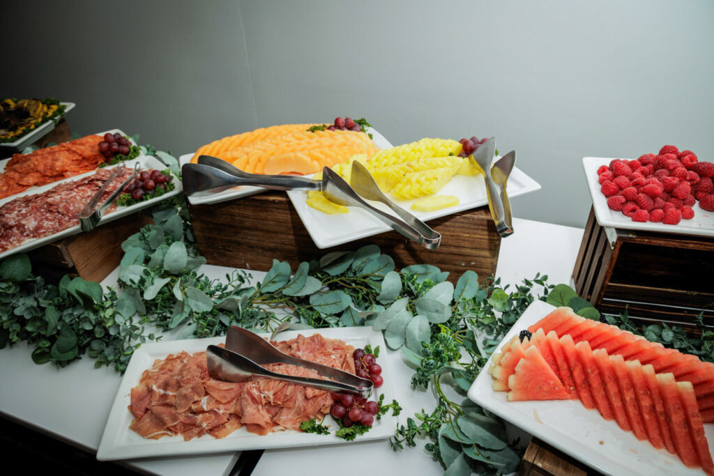 Elegant cocktail hour display with fresh fruit and charcuterie surrounded by eucalyptus at Crystal Plaza