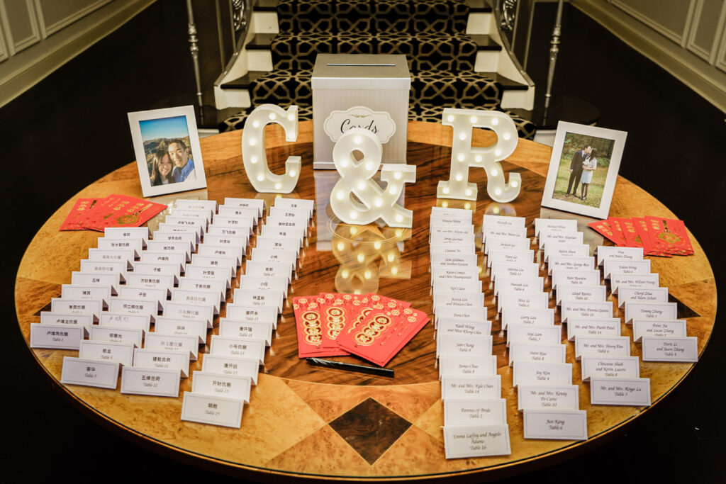 Wedding escort card table with red envelopes and illuminated monogram letters at Crystal Plaza in Livingston NJ