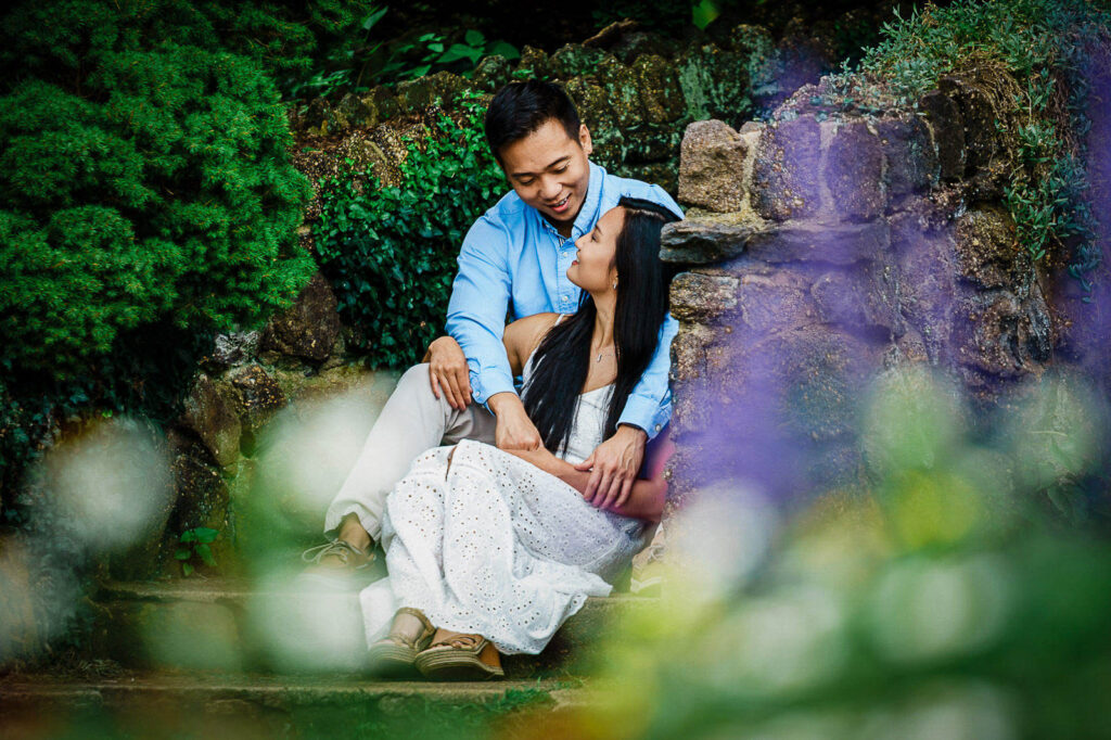 Couple sharing a quiet moment on garden path near stone colonnade in Bergen County NJ
