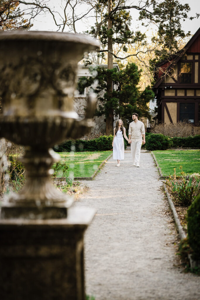 Couple walking hand in hand and laughing on garden path at Van Vleck House Gardens Montclair NJ