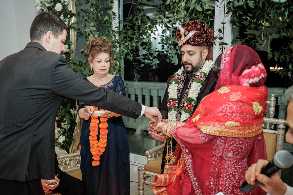 Family members participating in Hindu wedding ceremony ritual at Crystal Plaza mandap in New Jersey
