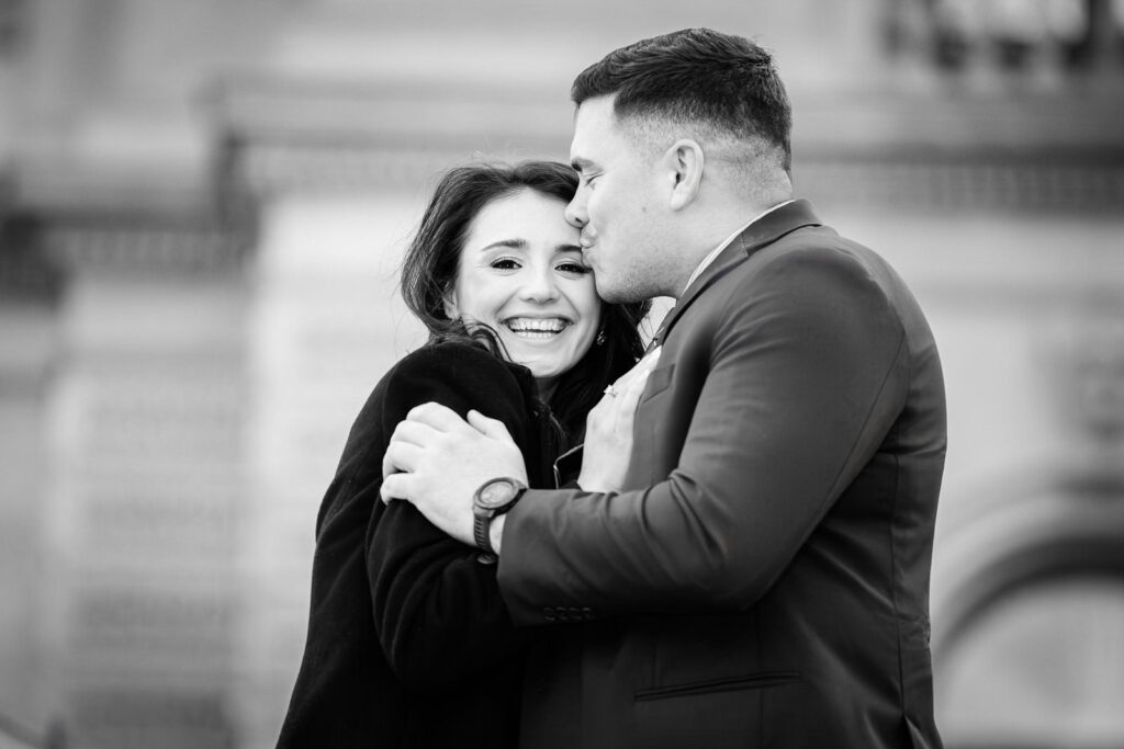 Black and white photo of man kissing partner's temple as she laughs at Library of Congress