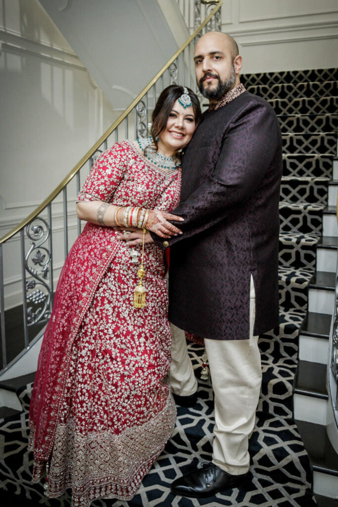 Multicultural wedding couple embracing on ornate staircase at Crystal Plaza New Jersey