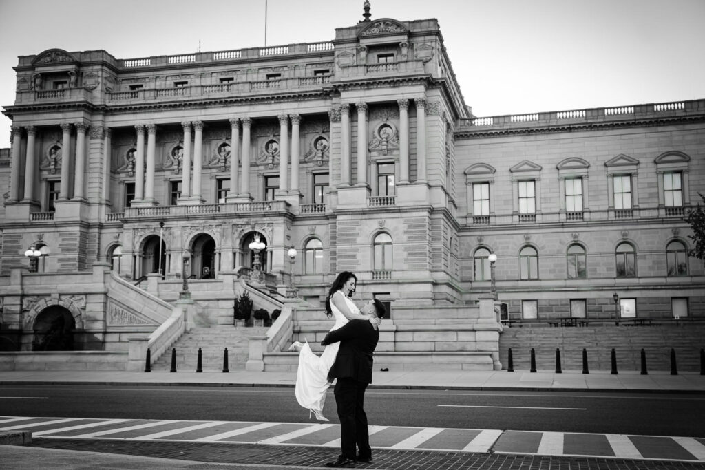 Black and white photo of man lifting his partner in the street in front of the Library of Congress