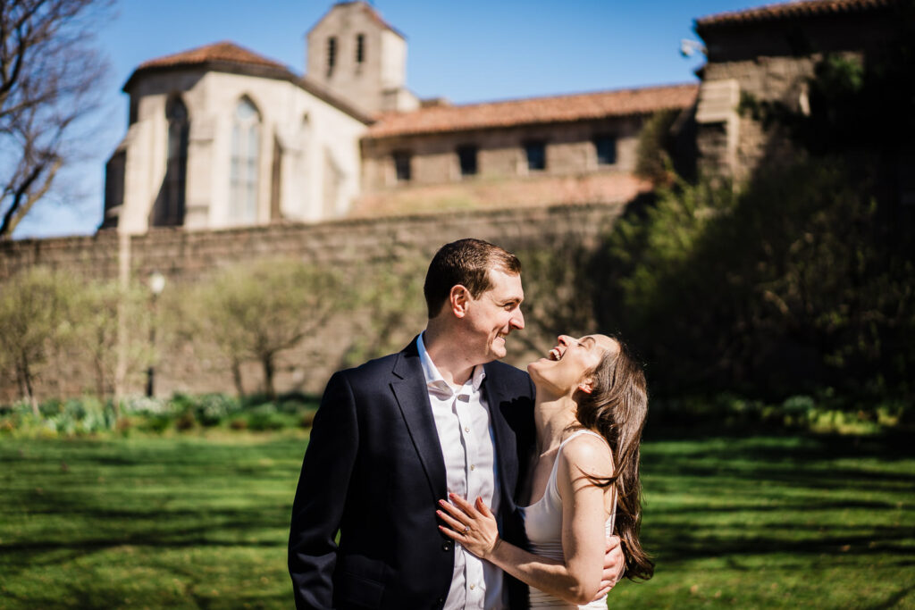 Couple laughing together on the open lawn outside The Met Cloisters in Fort Tryon Park New York
