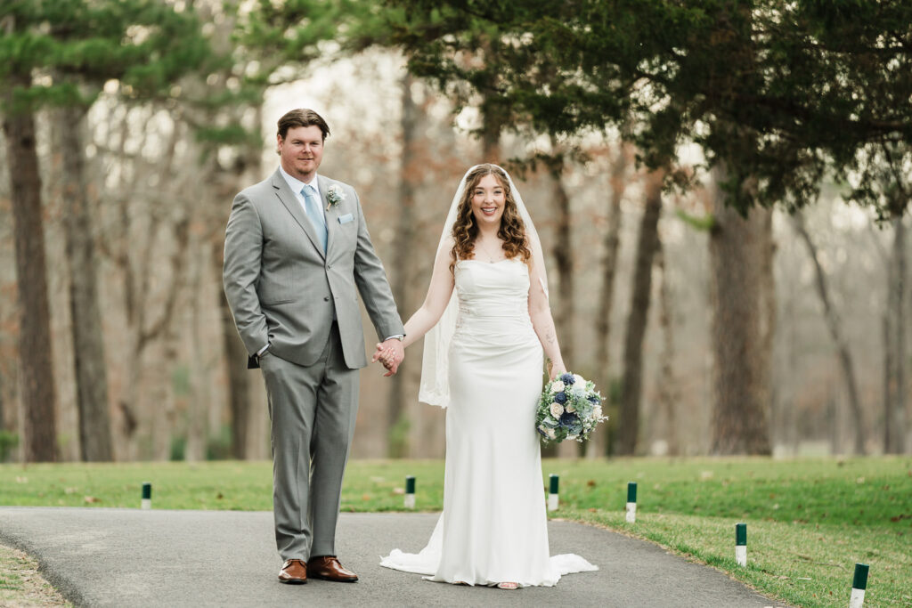 Bride and groom holding hands on tree-lined cart path at Pinelands Golf Club New Jersey wedding portraits