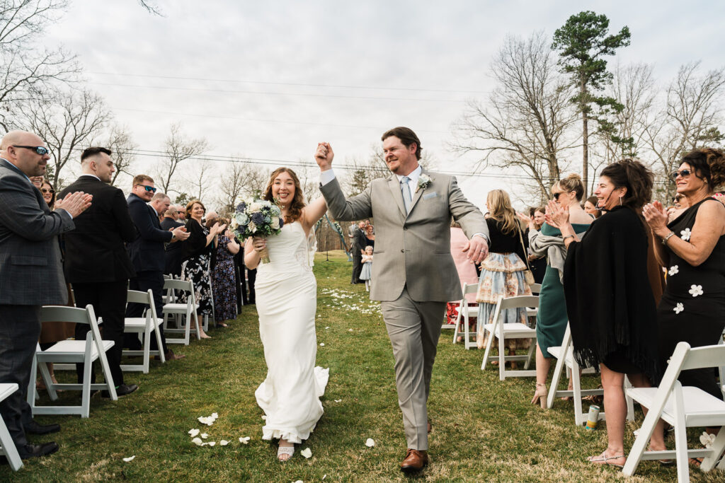 Joyful bride and groom recessional exit through guest-lined aisle at outdoor New Jersey golf club wedding