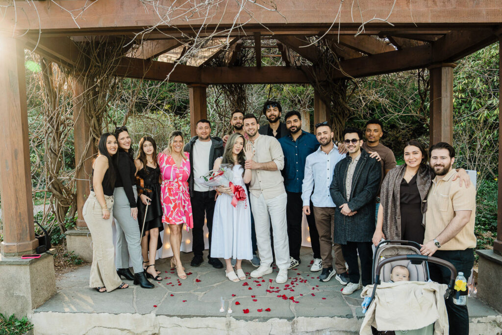 Newly engaged couple celebrating with family and friends after surprise proposal at Van Vleck NJ