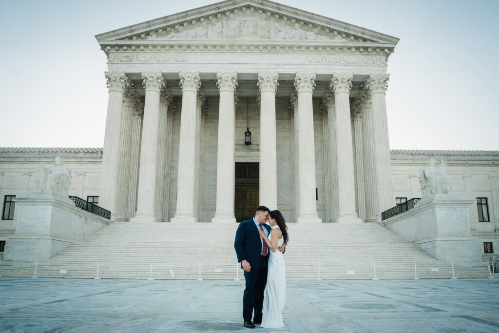 Engaged couple touching foreheads on the steps of the US Supreme Court at sunrise Washington DC