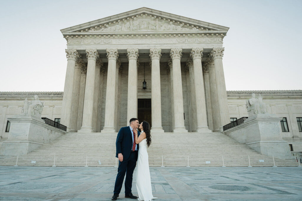 Couple kissing in front of the Supreme Court full facade at sunrise Washington DC