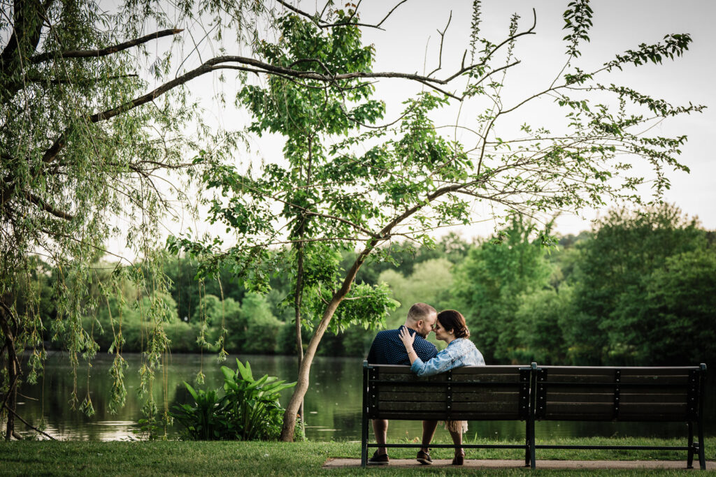 Couple walking along a tree-lined path during an engagement session at a New Jersey park