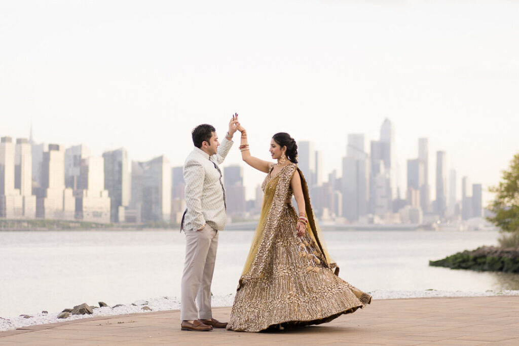 Bride twirling joyfully in her wedding gown with the Manhattan NYC skyline visible behind her at dusk