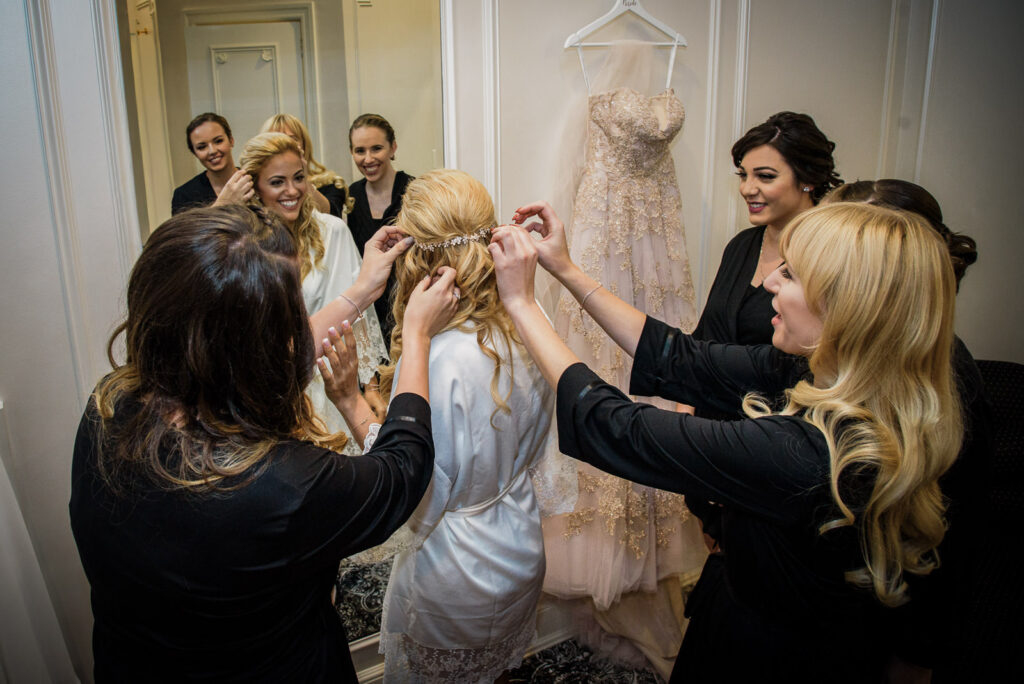 bridesmaids helping bride with hair piece crystal plaza bridal suite nj getting ready
