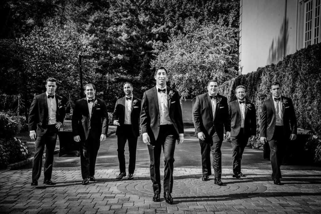 groomsmen walking toward camera crystal plaza wedding nj black and white portrait