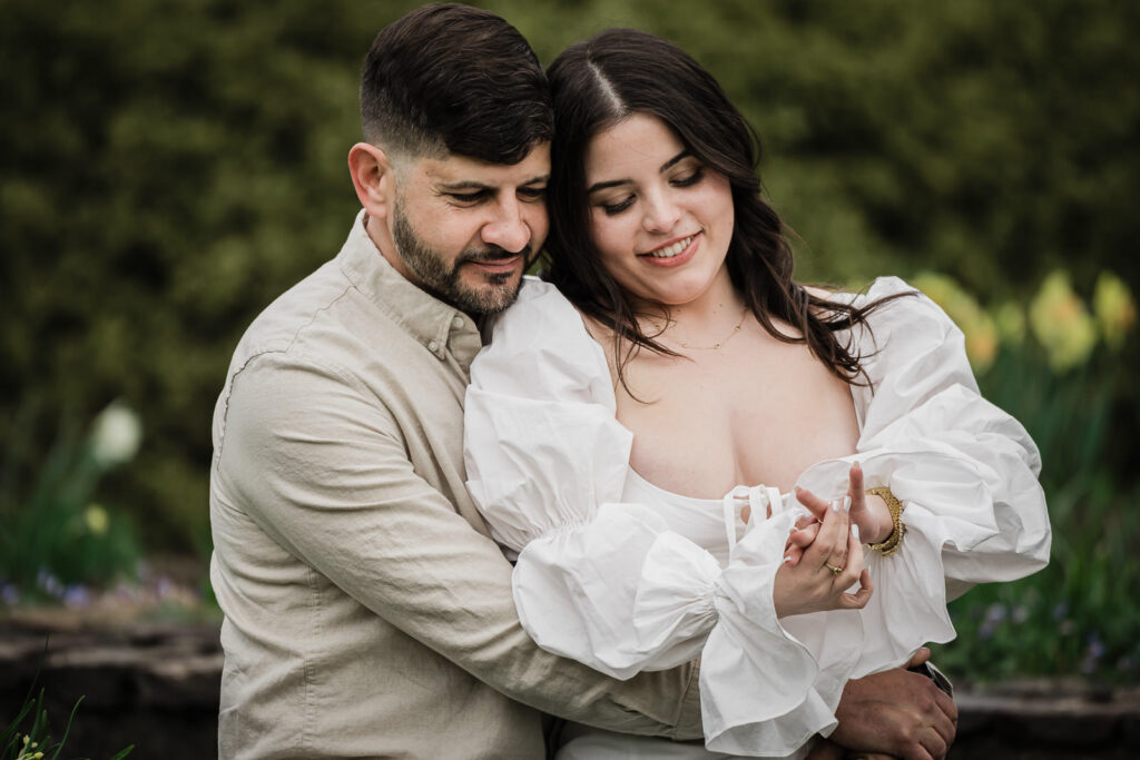 Dryellen looking at her engagement ring while Luiz watches — Deep Cut Gardens Middletown NJ