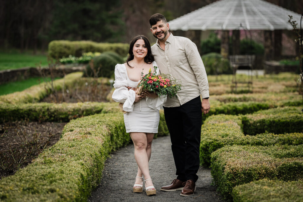 Luiz and Dryellen smiling together with bouquet after their Deep Cut Gardens NJ proposal