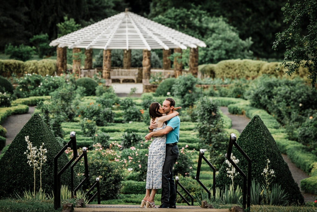 Couple embracing and sharing a first kiss right after a surprise outdoor proposal at Deep Cut Gardens in New Jersey photographed by Alex Kaplan