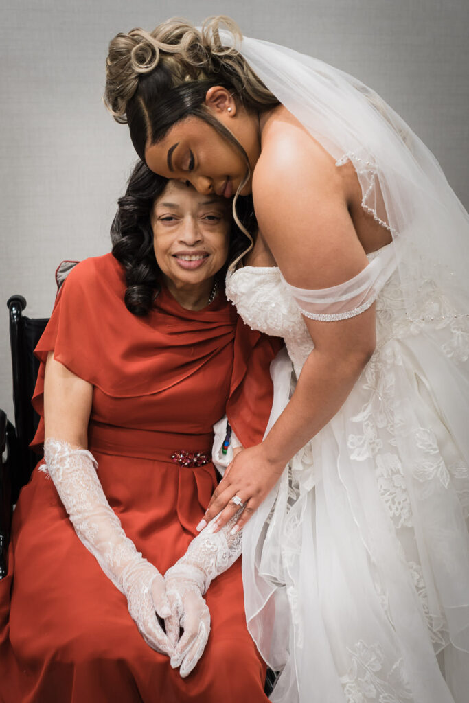 Bride leaning in to kiss mother on wedding day before ceremony at Sheraton Parsippany Hotel NJ