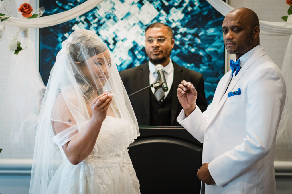 Bride examining wedding ring during ceremony exchange at Sheraton Parsippany Hotel New Jersey