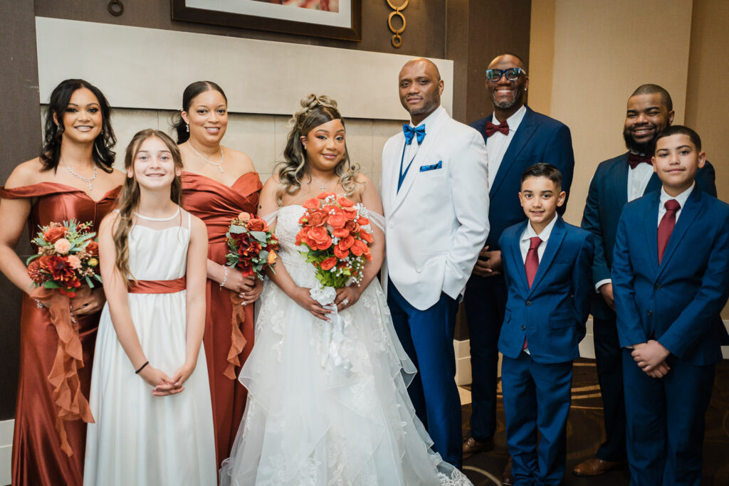 Bride groom and full wedding party posing together in hotel corridor at Sheraton Parsippany NJ wedding