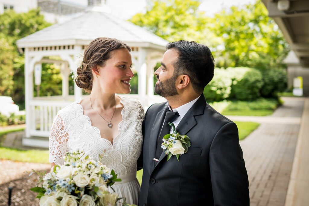 Couple smiling at each other during portrait session at Bergen County Plaza gazebo in Hackensack New Jersey