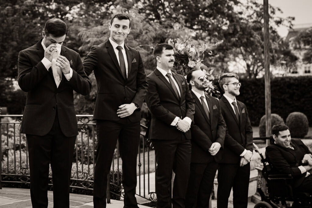 Emotional groom wiping away tears during an authentic New Jersey wedding ceremony