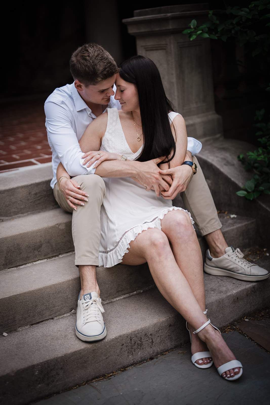 Alt text: Couple embracing on stone steps during an engagement session at Van Vleck House in Montclair NJ