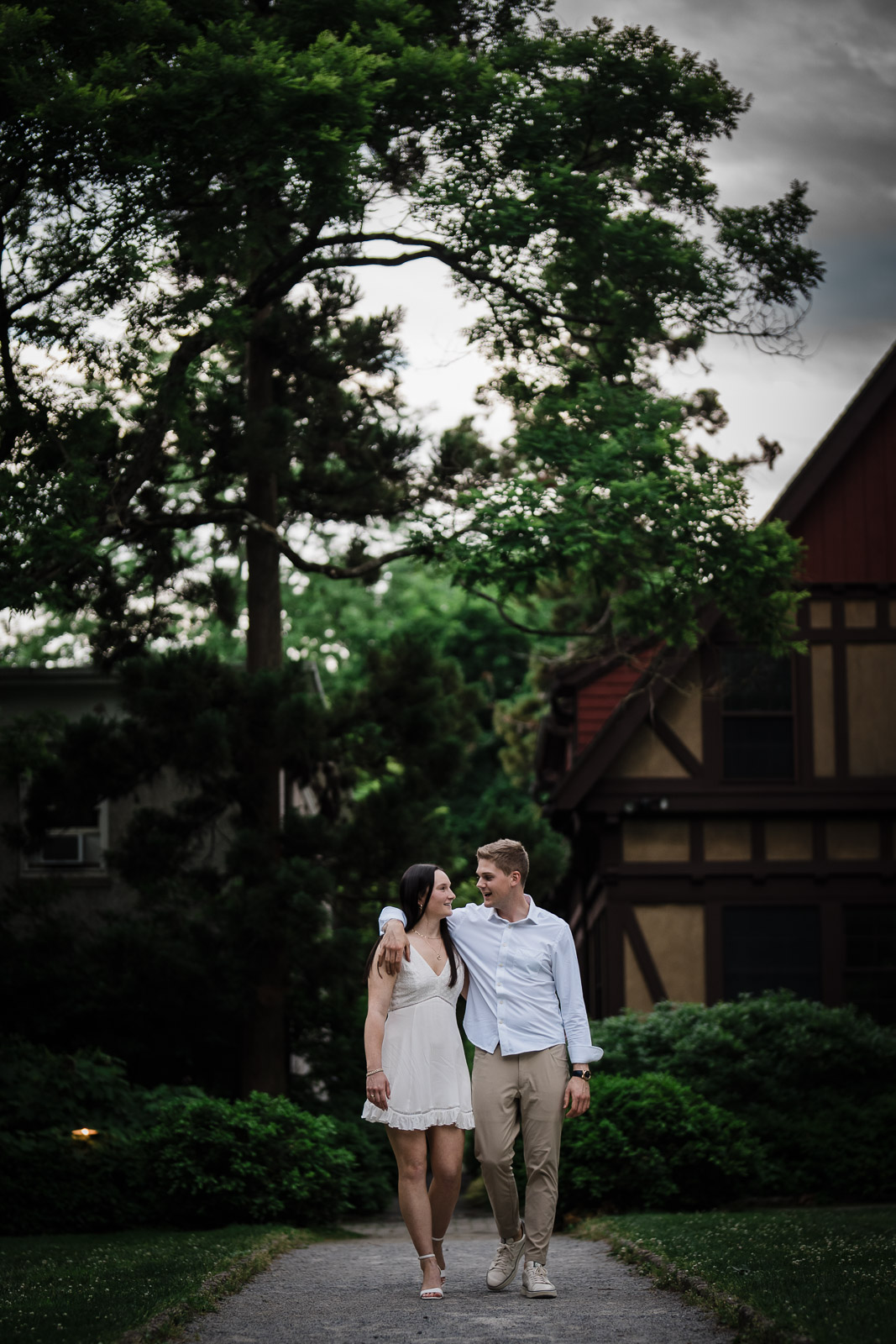 Engaged couple walking a tree lined path on the grounds near Van Vleck in Montclair