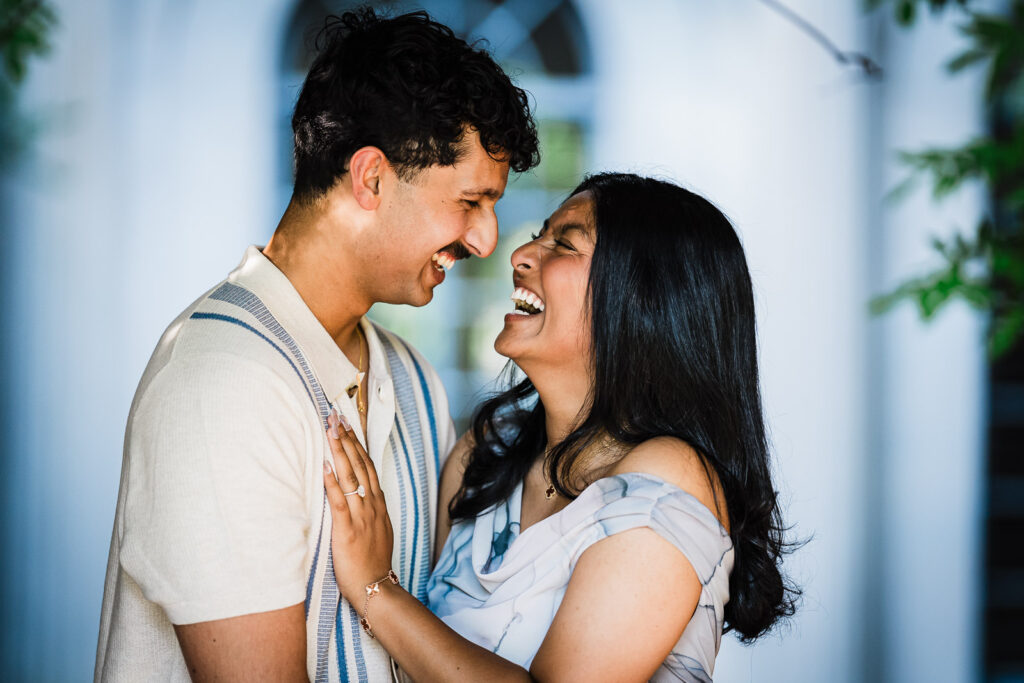 Newly engaged couple laughing together with engagement ring visible at Van Vleck Gardens Montclair NJ