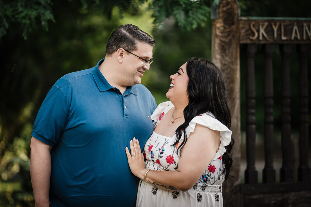 Engaged couple beside the Skylands estate entrance sign in Ringwood New Jersey
